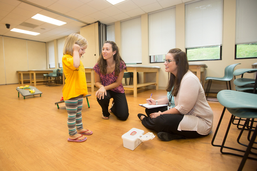 Student clinicians working with toddler